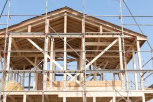 上棟を終えた木造軸組の骨組み、青空を背景にした施工中の現場