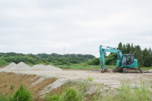 整地された敷地に重機が入る、着工前の現場
