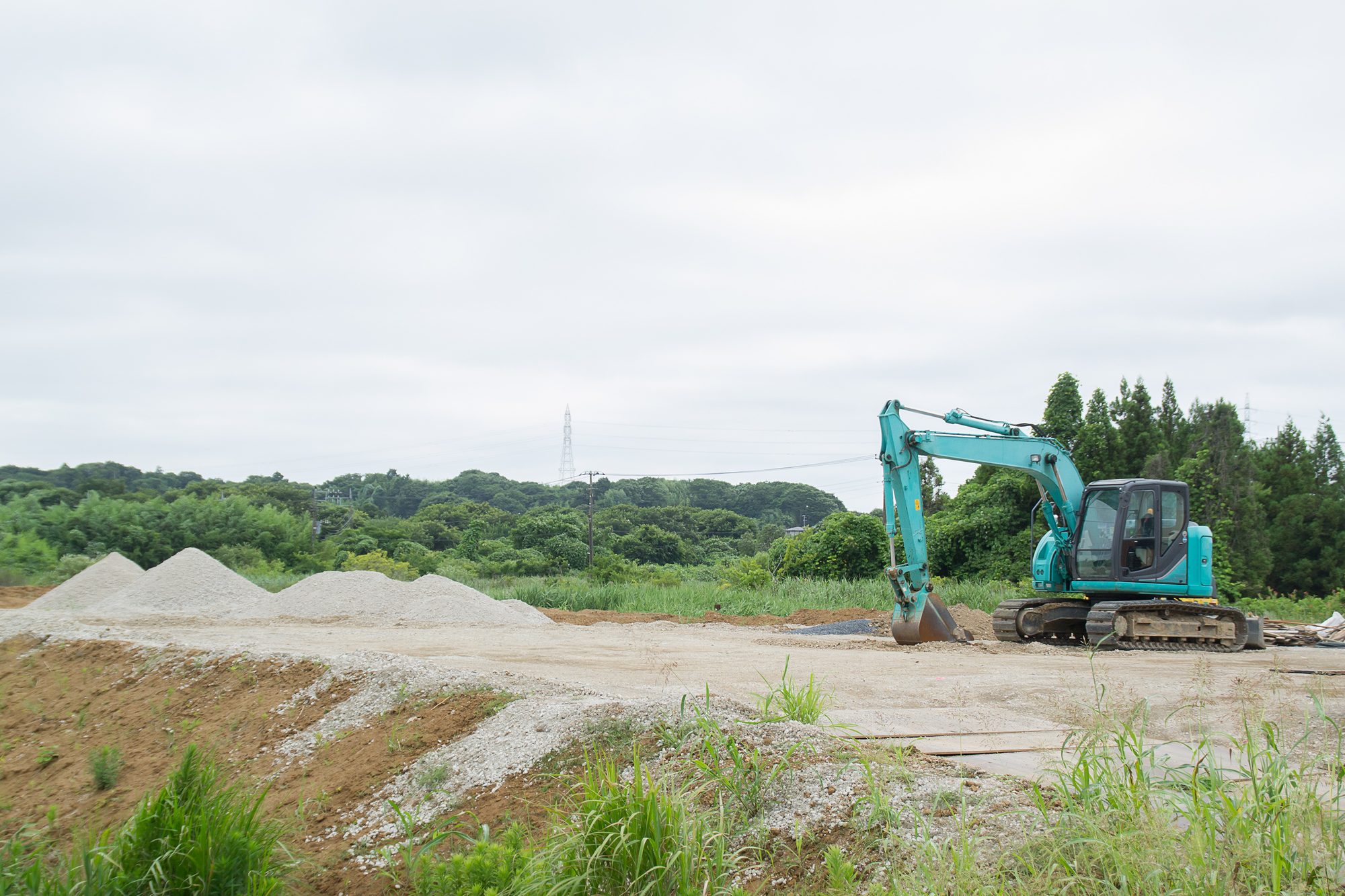整地された敷地に重機が入る、着工前の現場